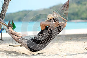 Lifestyle freelance man relax and sleeping on the hammock after using laptop working and relax on the beach.